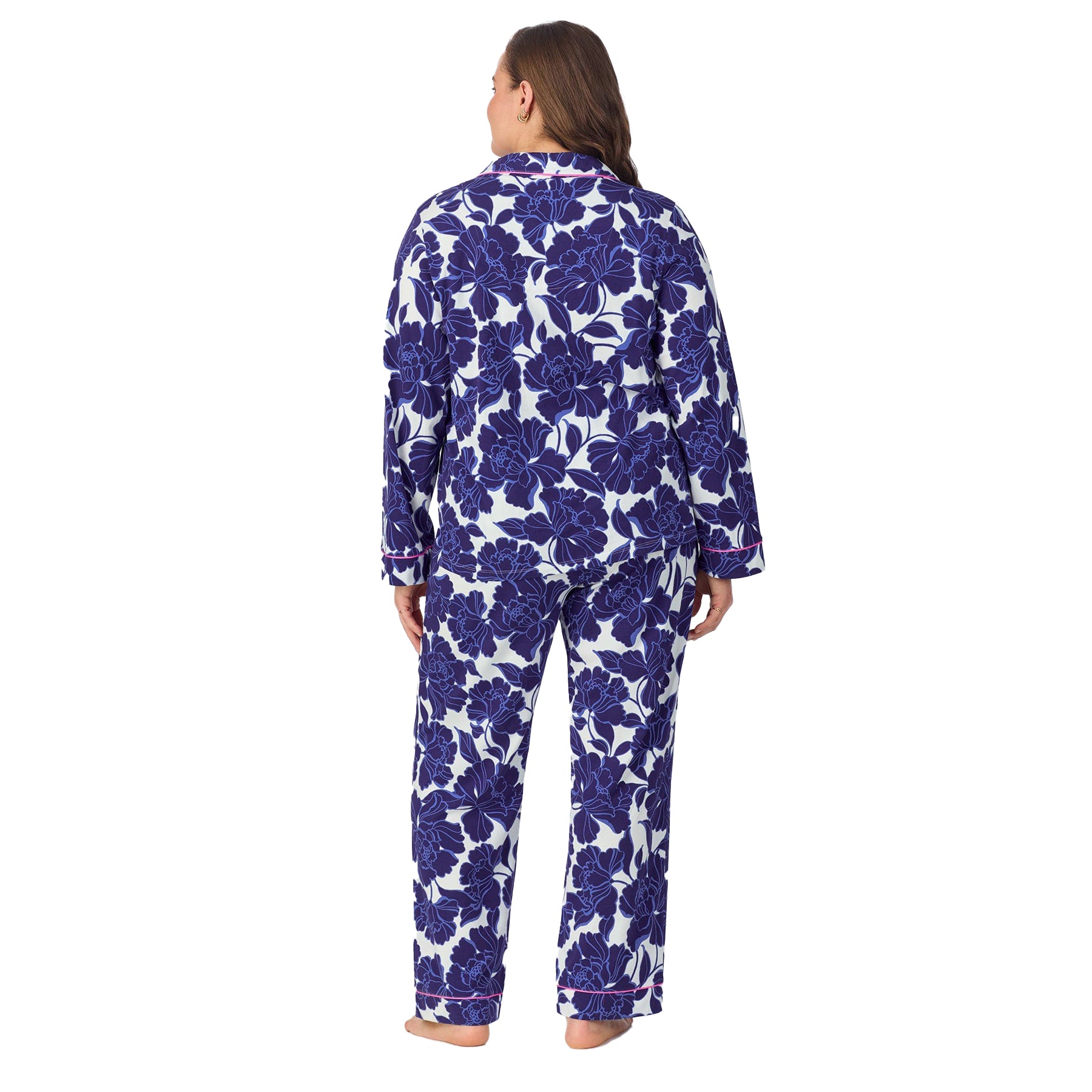 Back view of a plus-size model in a navy and white floral pajama set with full-length pants and long sleeves.