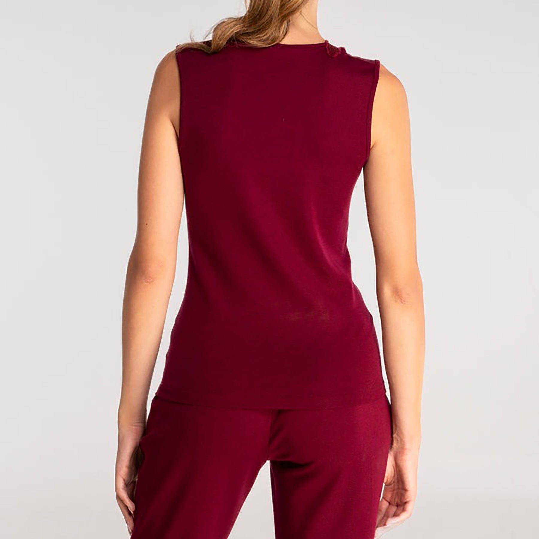 Sleeveless knit top in burgundy sangria made of wool and silk with Guipure lace embroidered neckline. On model rear view.