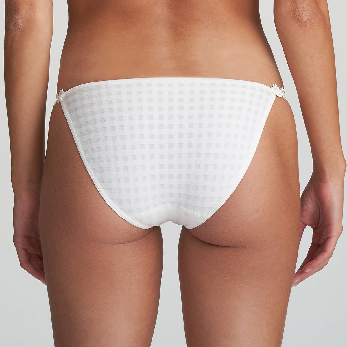 Low rise bikini panty in natural ivory with embroidered daisy string at hips. Rear view on model.