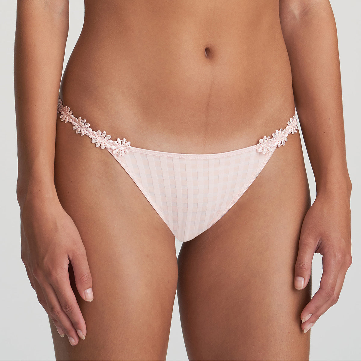 Low rise bikini panty in pearly pink with embroidered daisy string at hips. Front view on model.