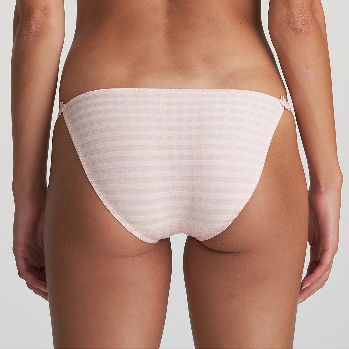 Low rise bikini panty in pearly pink with embroidered daisy string at hips. Rear view on model.