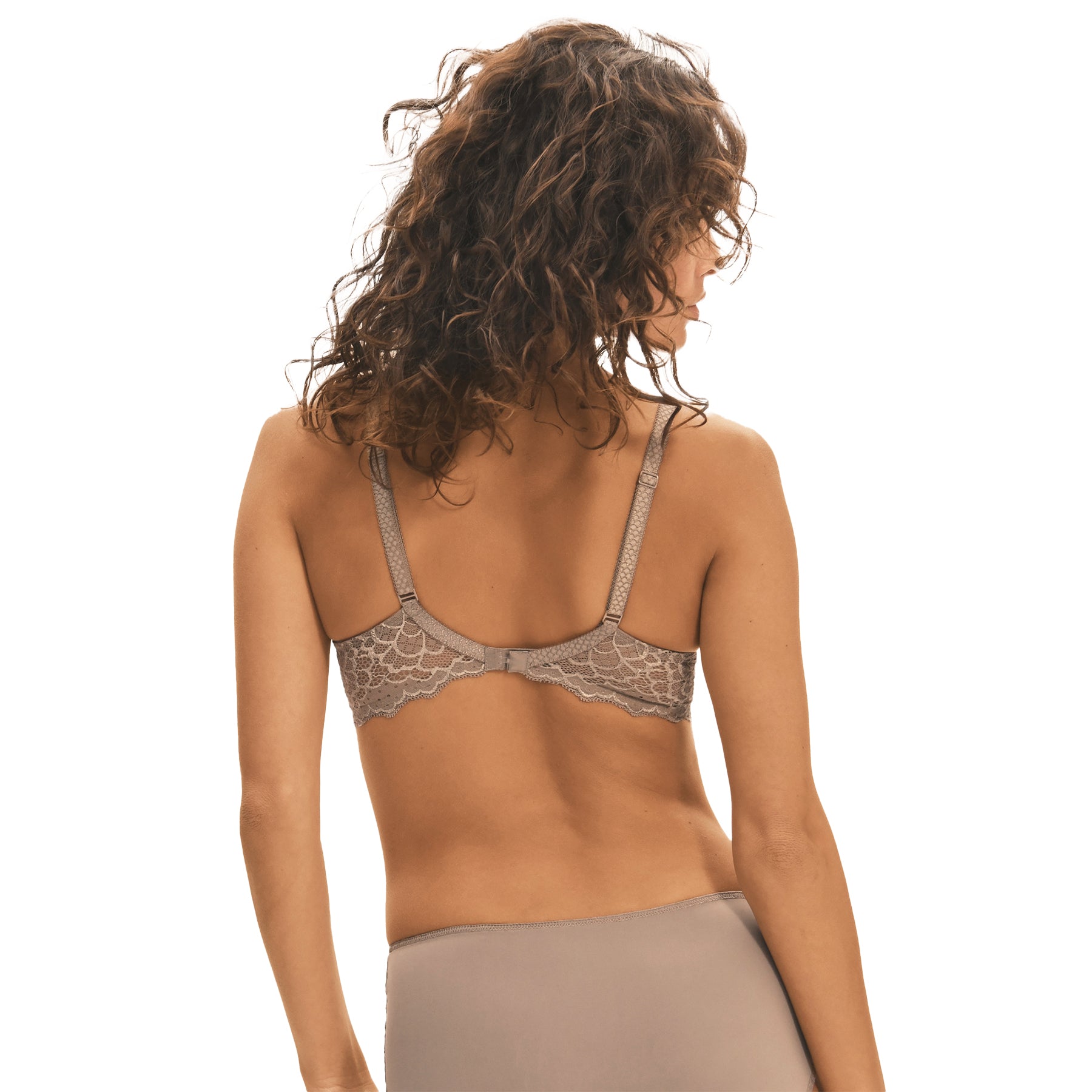 A model showing a grey/nude set of lacey basic lingerie from Simone Perele on a white background, back view.