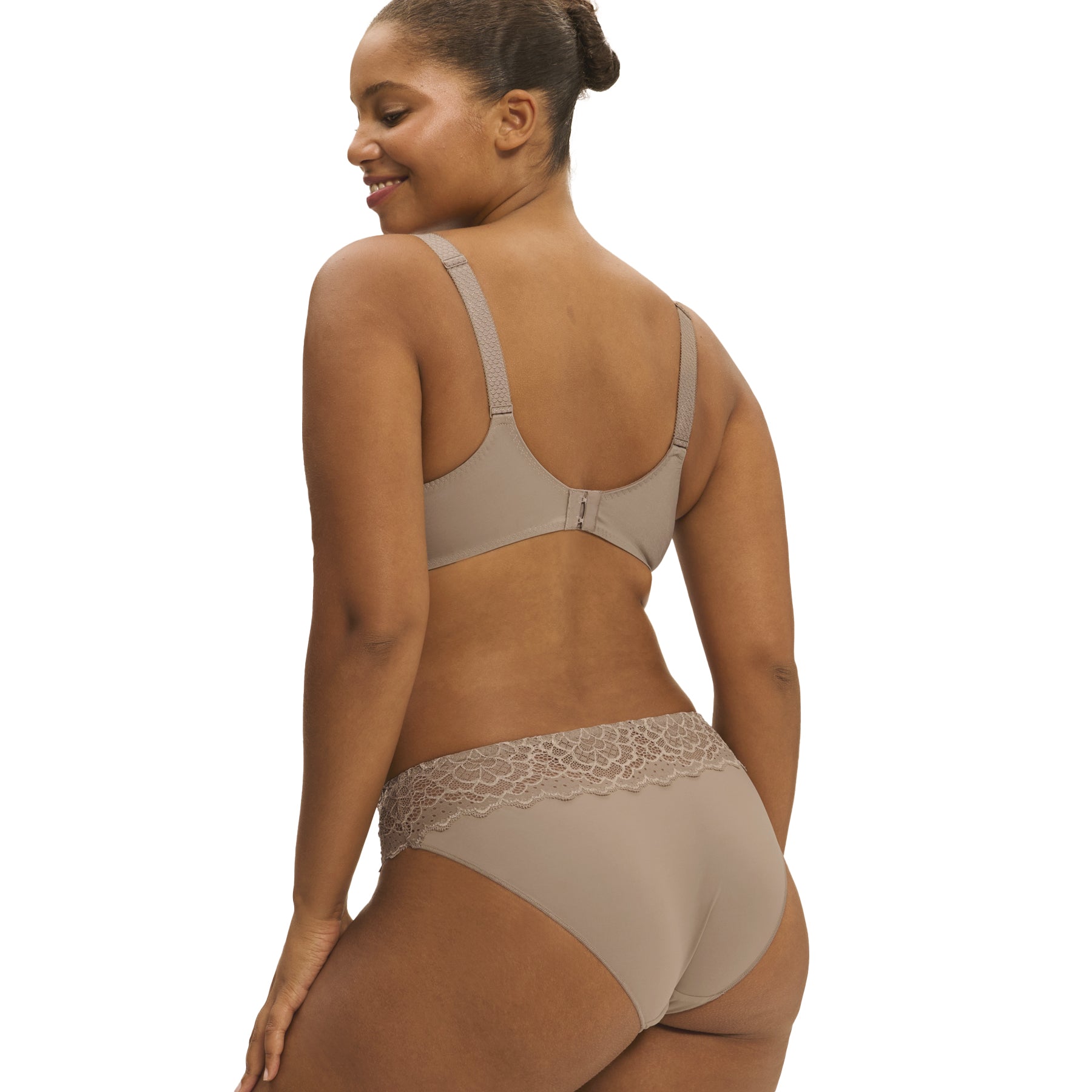 A model showing a grey/nude bikini brief seamless panty on a white background, back view.