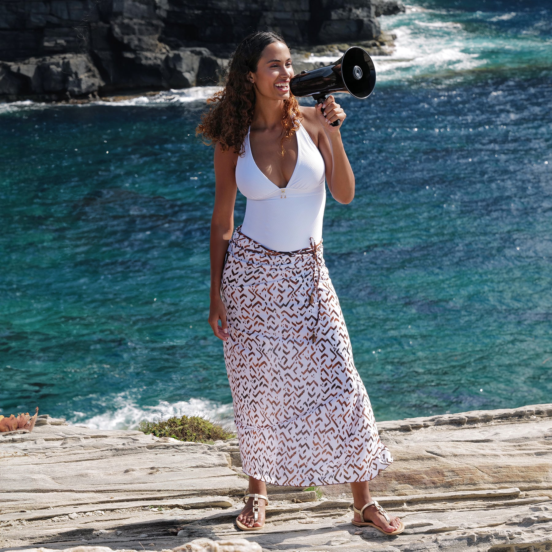 Pareo swim cover/sarong in ethno blanc print with side ties and tassel detail. Brown print on a white background. Front view on model.