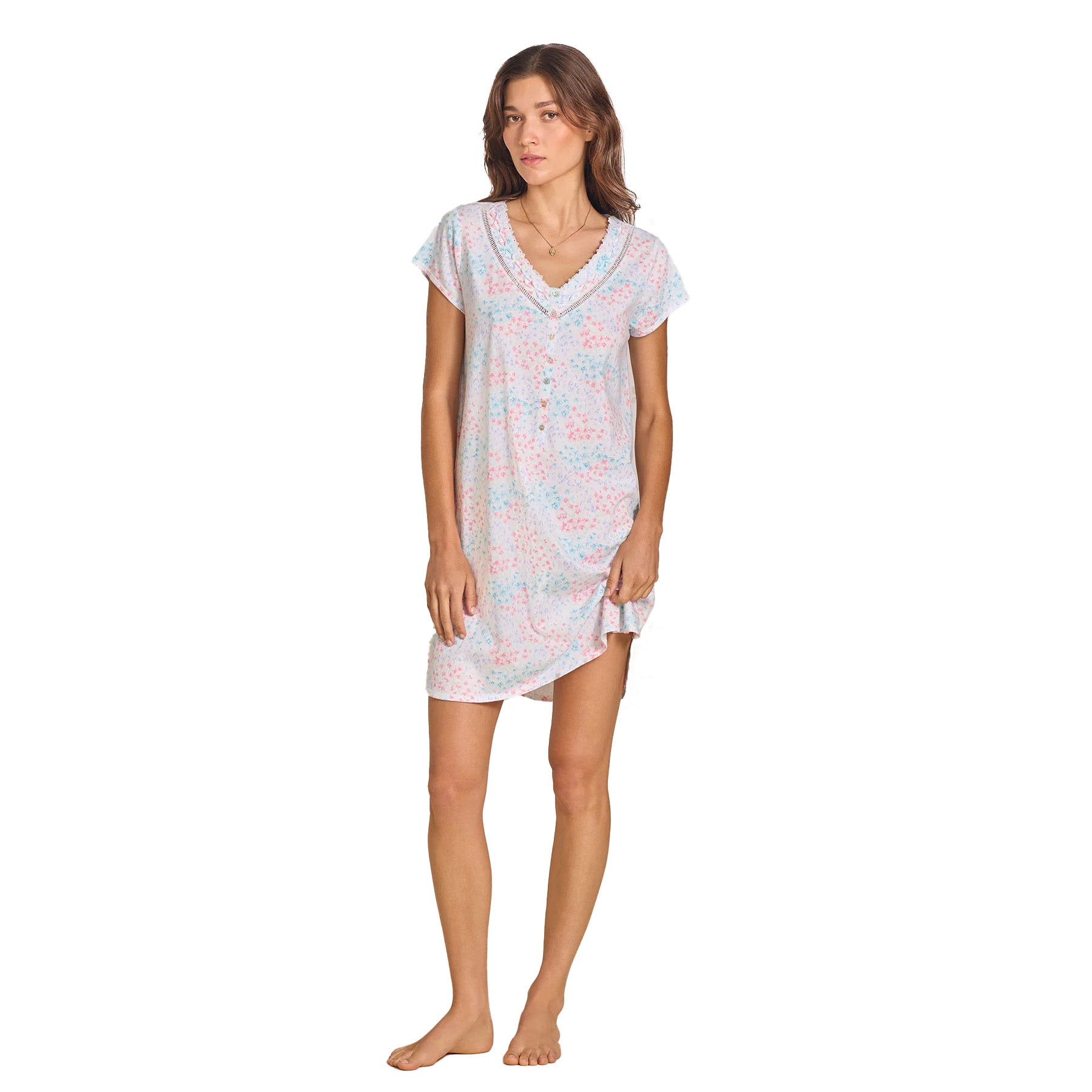 The same model in the floral nightgown, lifting the hem slightly, showing the comfortable fit and flowy design.