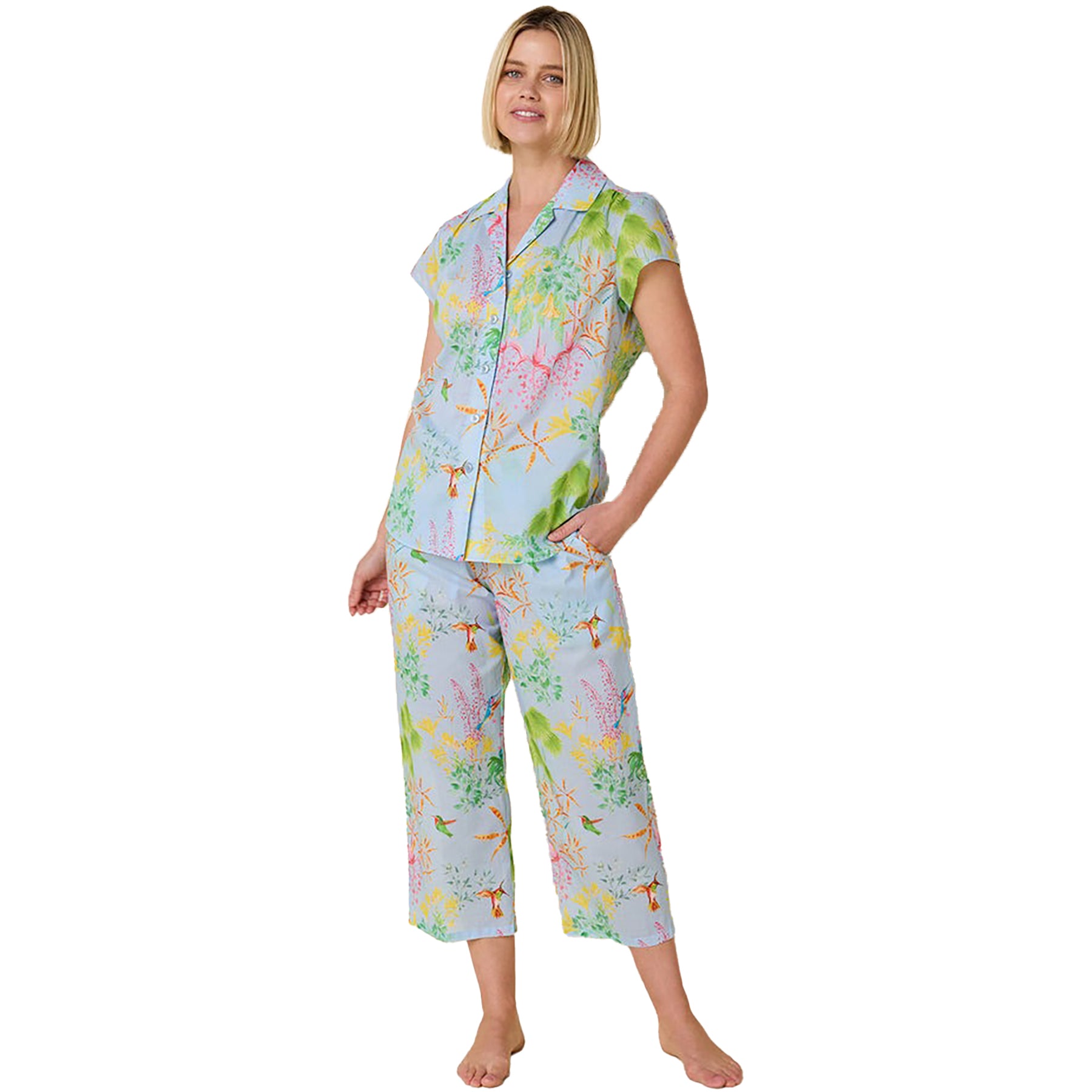 short sleeve button up pajamas with matching capri pants in a multicolour hummingbird print on a blue background. Front view on model.