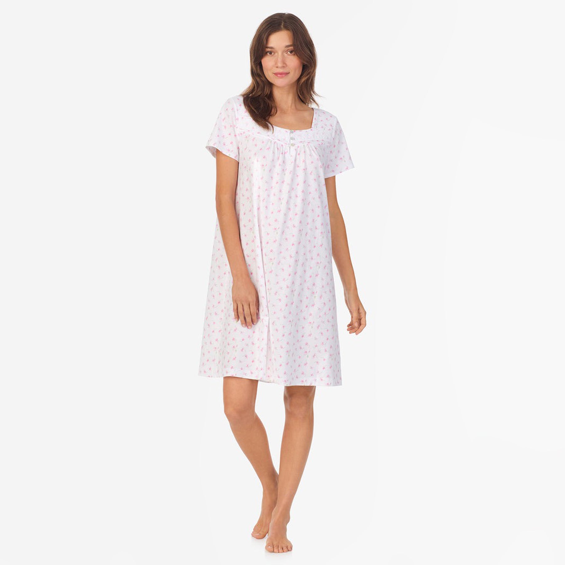 Front view of a women's floral nightshirt in a "petite pink floral" print showcasing intricate lace trim and button detailing, fashion photoshoot.