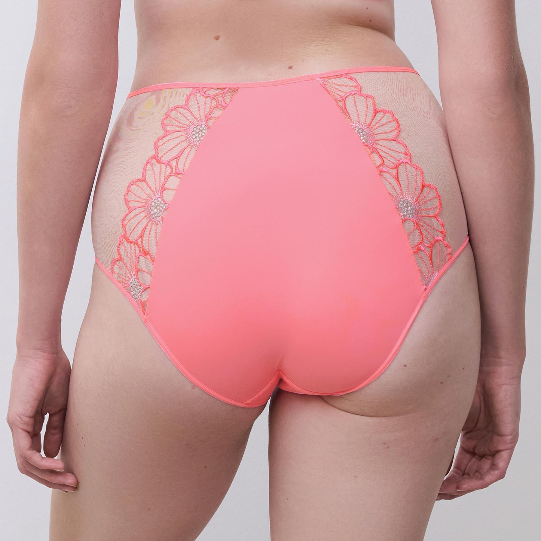 High-waist full brief in rose miami bubblegum pink with sheer tulle sides with daisy embroidery. Rear view close up on model.