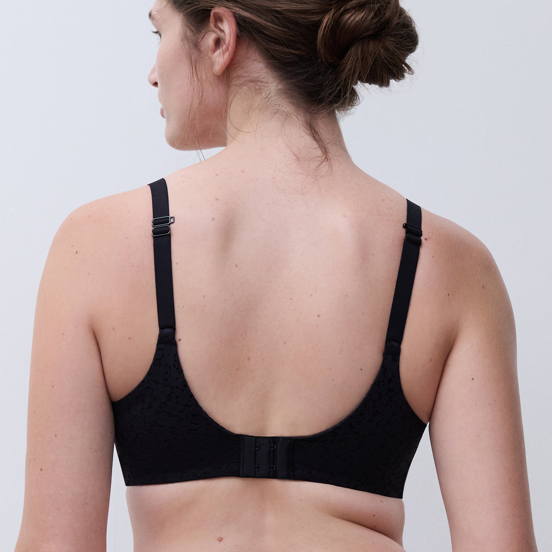 Chantelle molded full cup underwired spacer bra in black. Rear view on model.