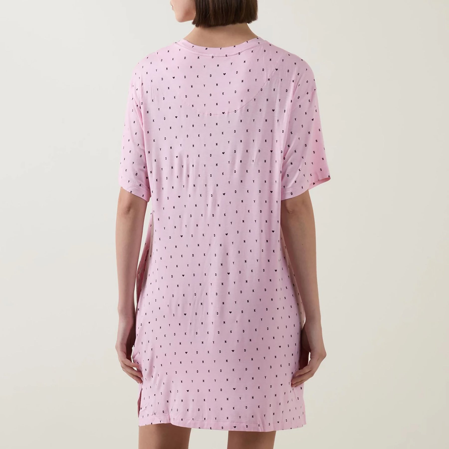 Short sleeve round neck sleepshirt in DKNY black mini logo and heart print on baby pink background. Rear view on model.