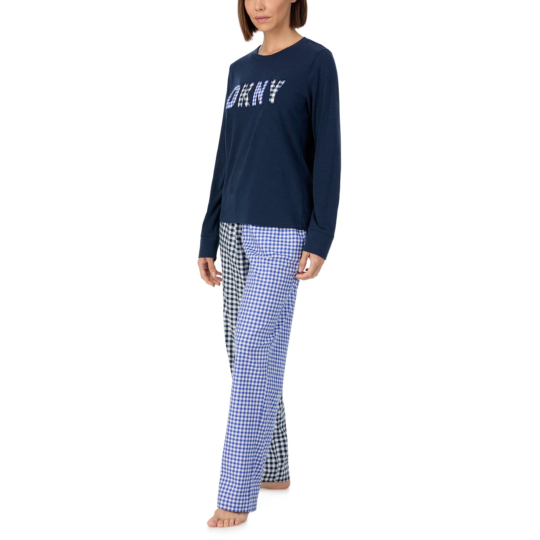 Long sleeve navy blue lounge top with DKNY gingham logo with matching black and blue gingham printed pants. Front/side view on model.