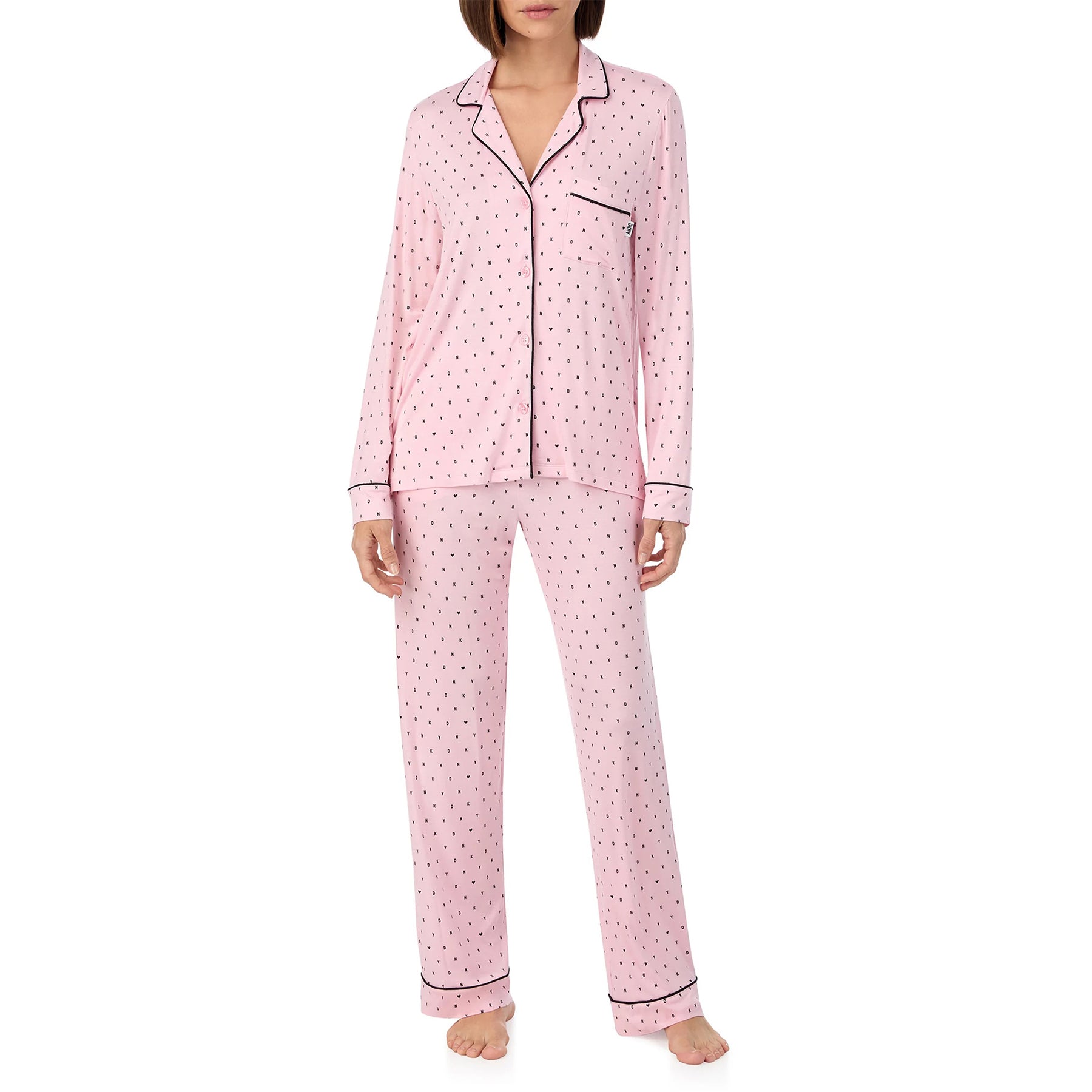 Classic button up 2-piece pyjama set in DKNY black mini logo and heart print on baby pink background. Front view on model.