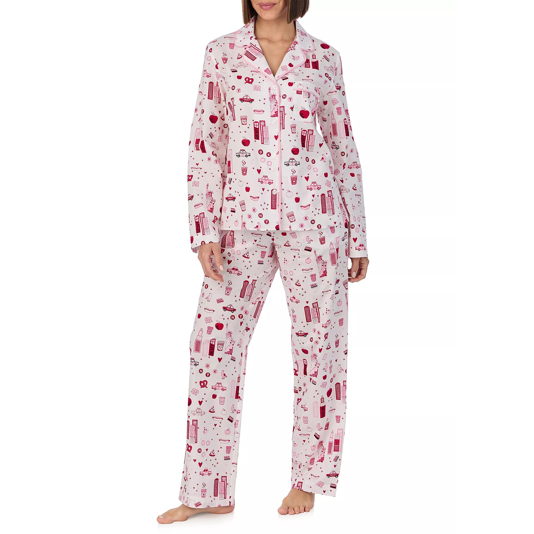 Classic 2-piece button up pyjama set printed with new york city items in red and pink on a white background. Front view on model.