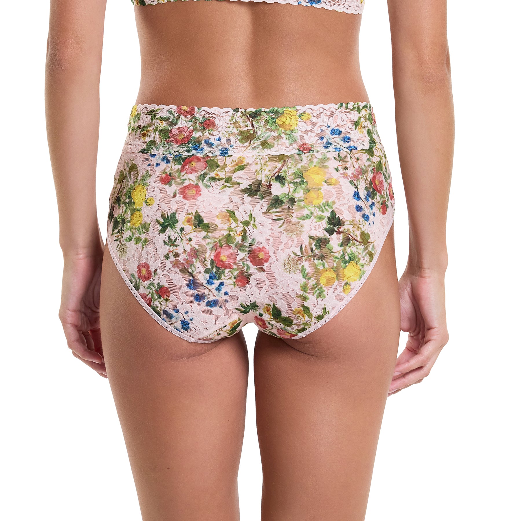 Printed lace high waist french cut full brief in pink, green and blue florals on a light pink background, rear view on model.