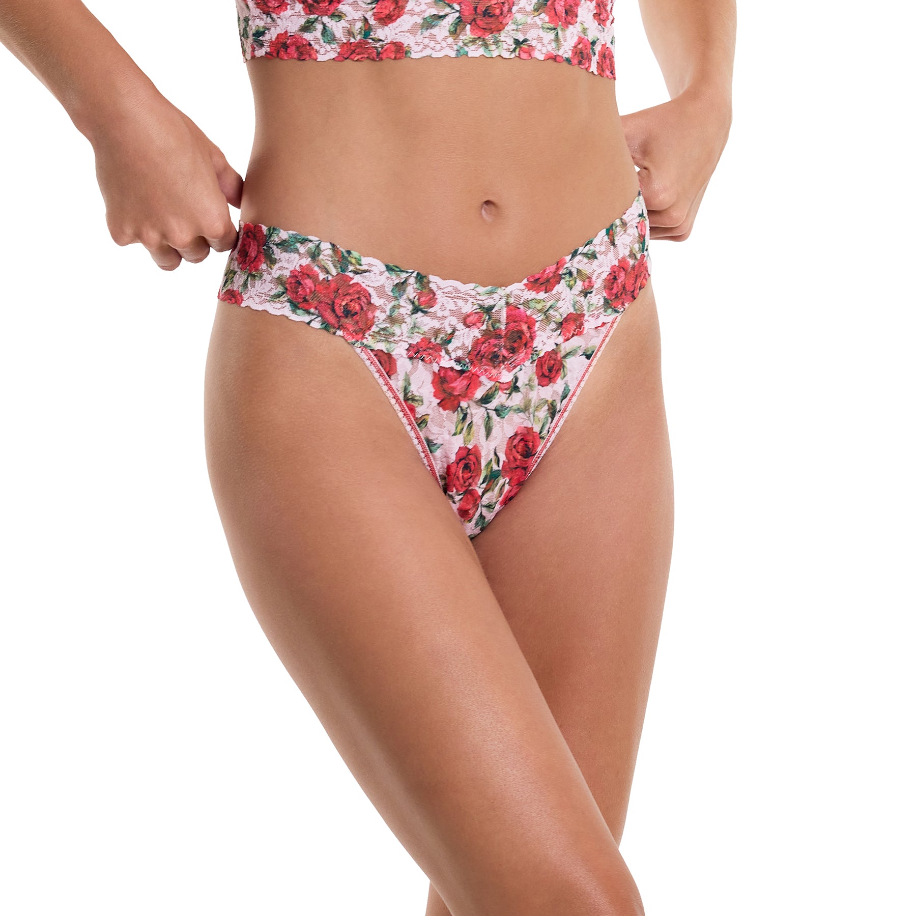 Je t'aime floral red/green rose printed lace original rise thong on a light pink background. Front/side view on model.