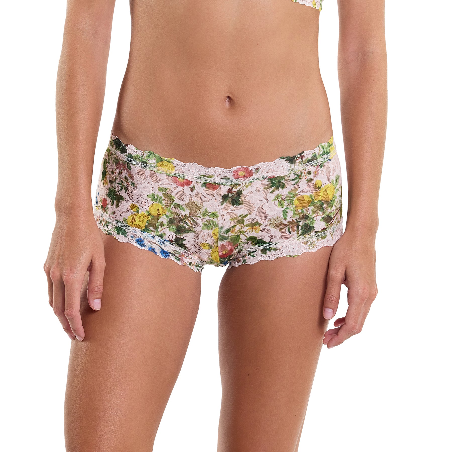 Printed lace boyshort in pink, green and blue florals on a light pink background. Front view on model.