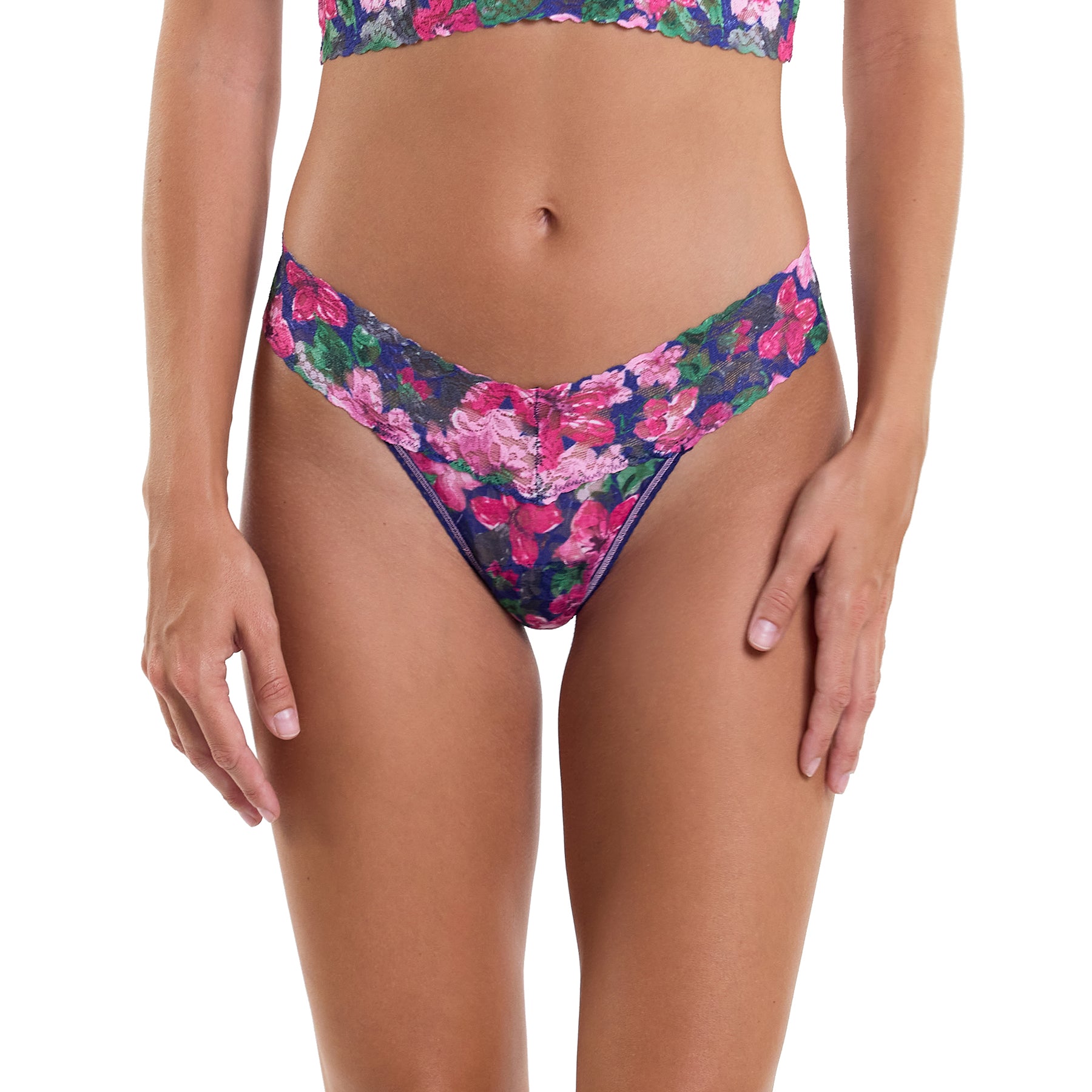 Printed lace low rise thong in tis the season, pink and green florals on a navy background. Front view on model.