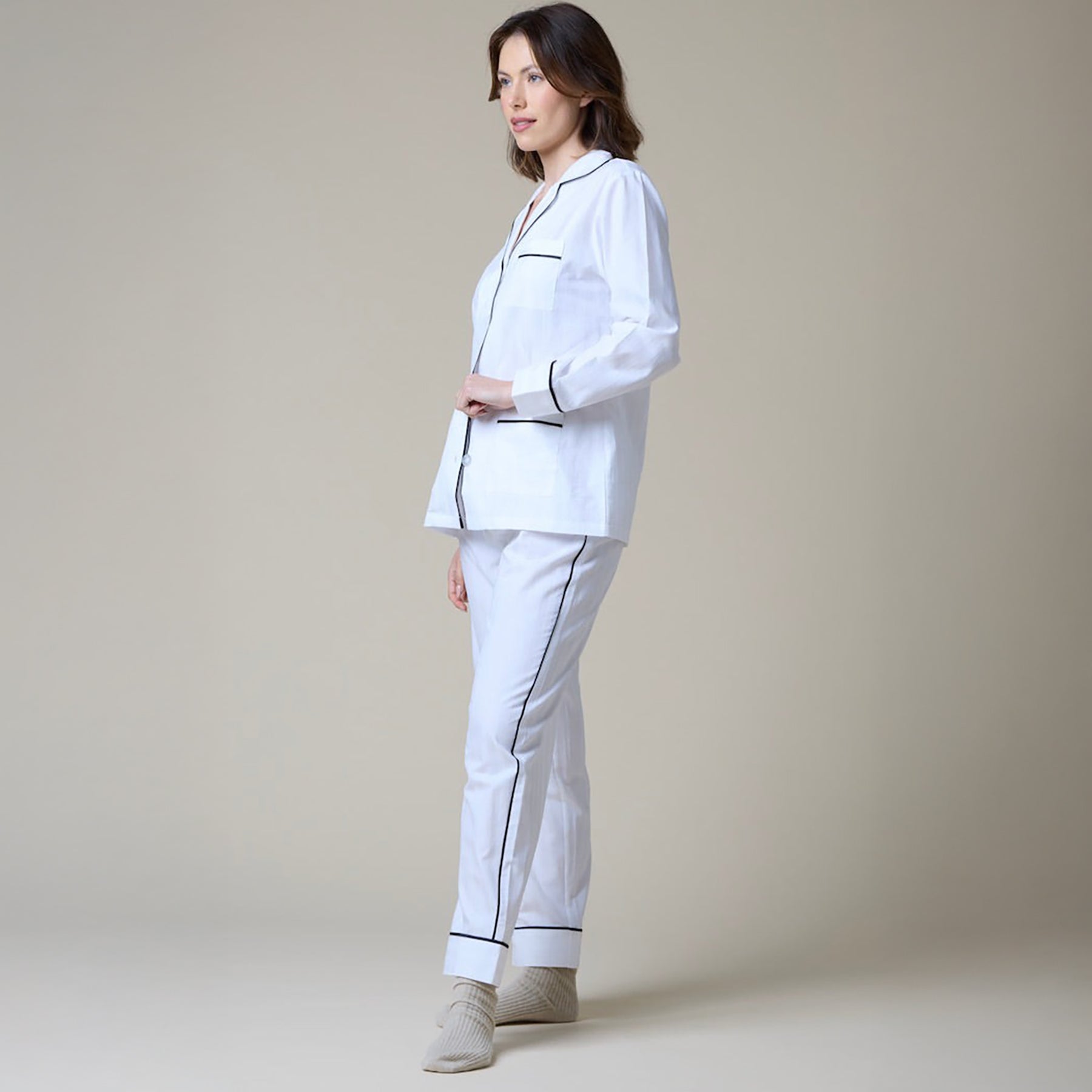 White cotton classic pyjama set with contrast black piping. Side view on model.