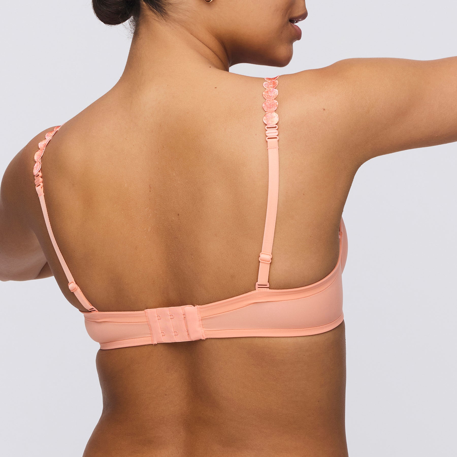 Seamless padded plunge heart shaped bra in papaya smoothie orange peach. Rear view close up on model.