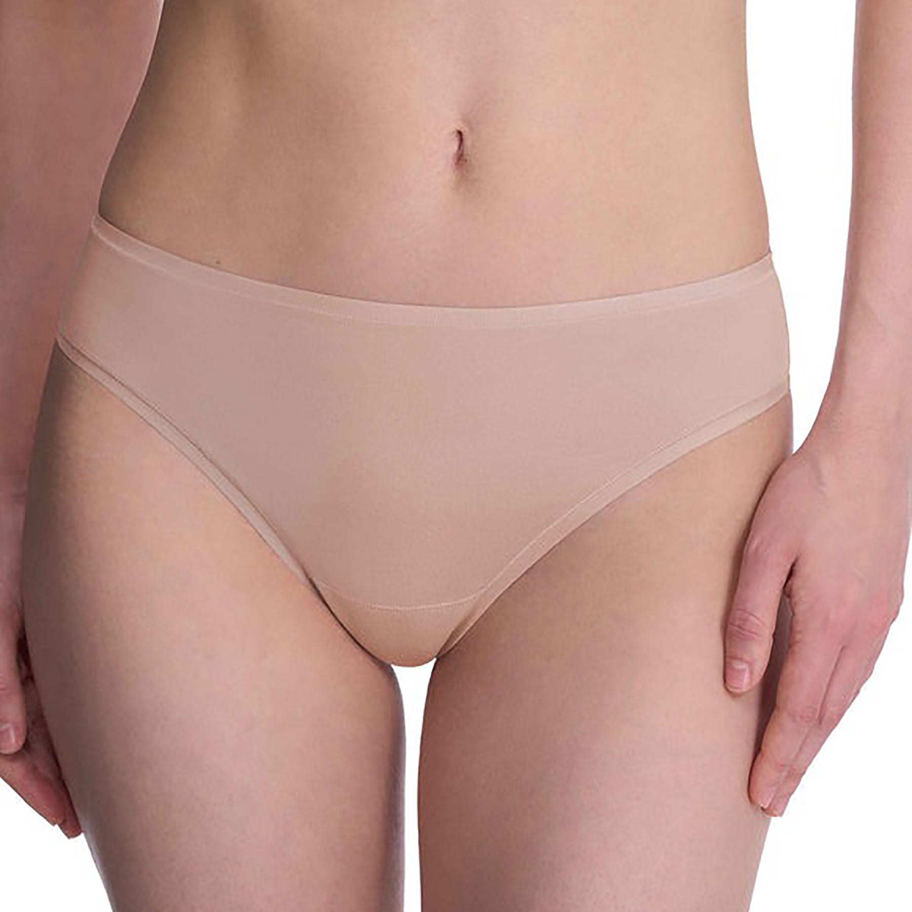 Seamless pima cotton mid-rise thong in cafe nude. Front view close up on model.