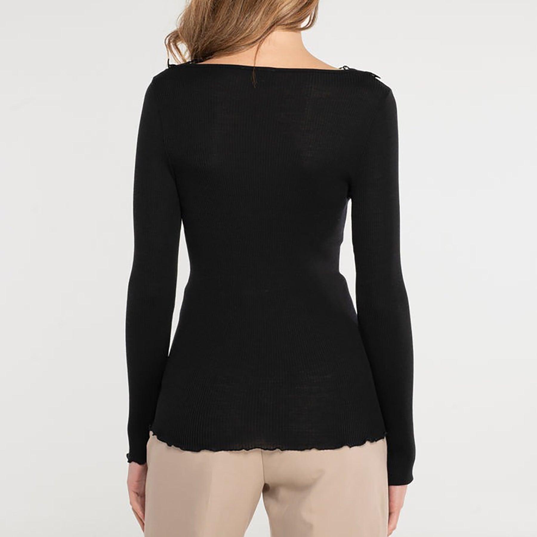 Long sleeve ribbed knit top in black made of wool and silk with Guipure lace embroidered neckline. Rear view on model.