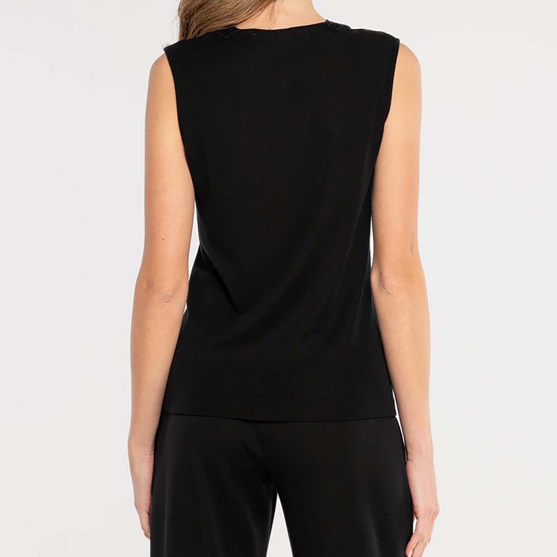 Sleeveless knit top in black made of wool and silk with Guipure lace embroidered neckline. On model rear view.