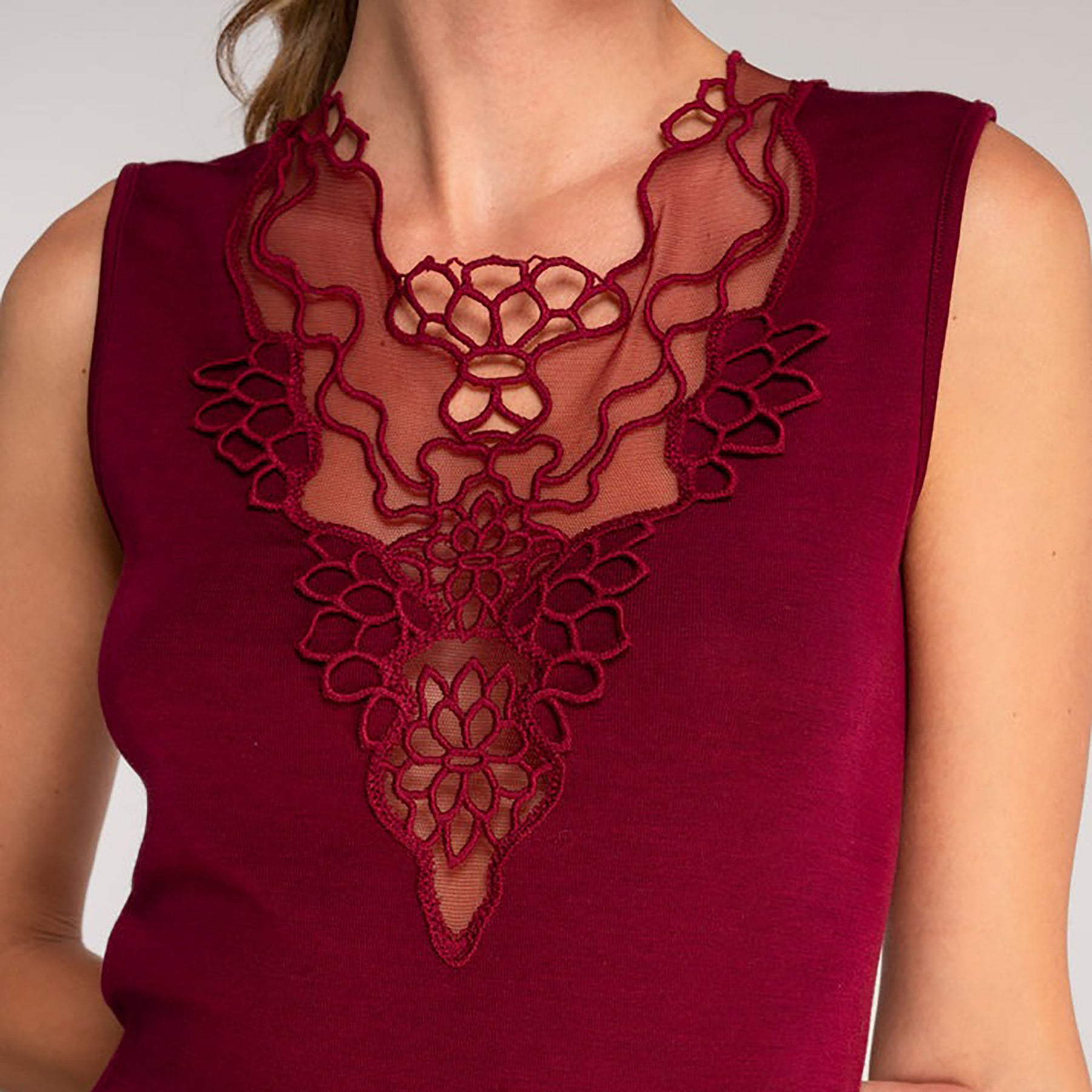 Sleeveless knit top in burgundy sangria made of wool and silk with Guipure lace embroidered neckline. Closeup on model front view.