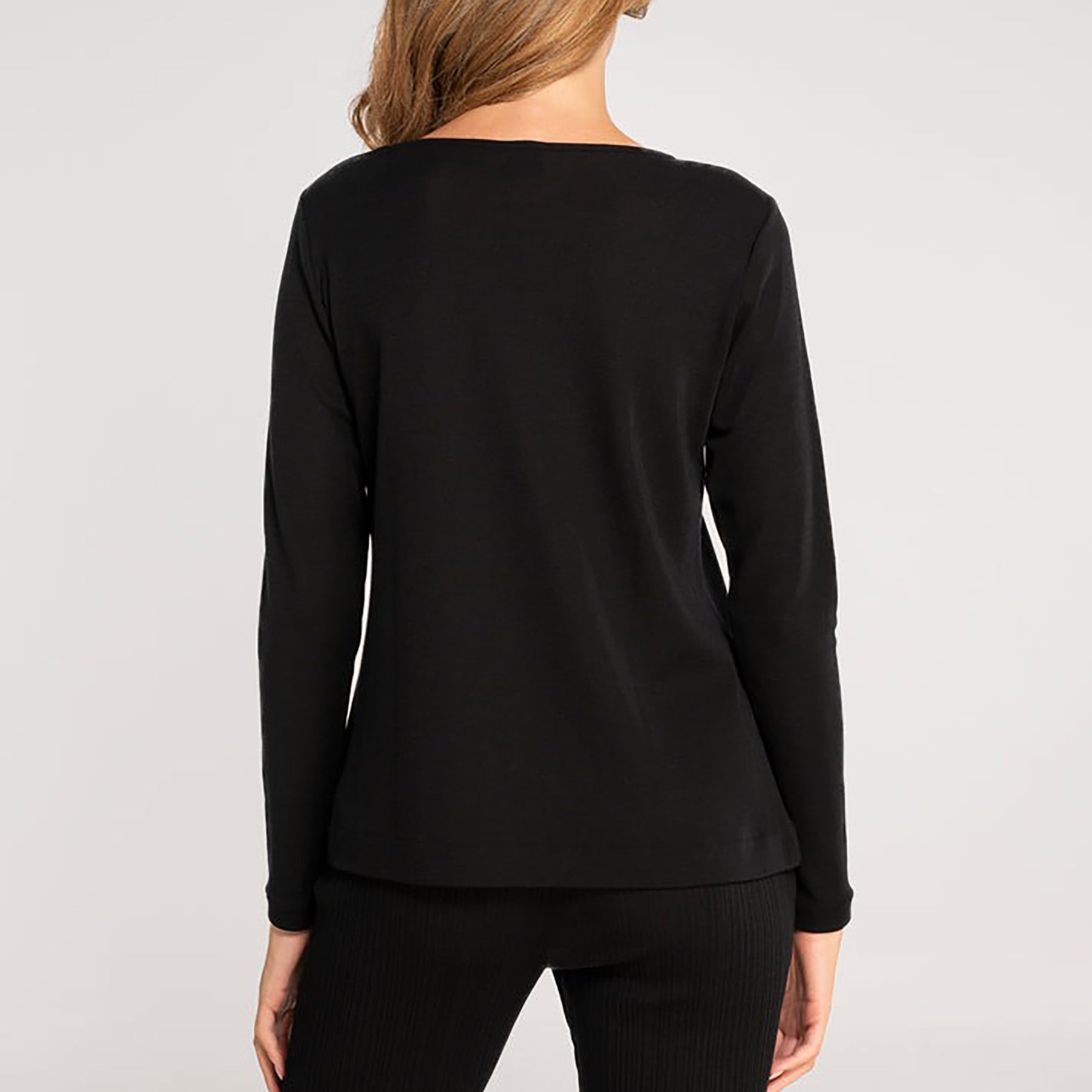 Long sleeve round neck top with keyhole silver metal ring at neckline in black. On model rear view.