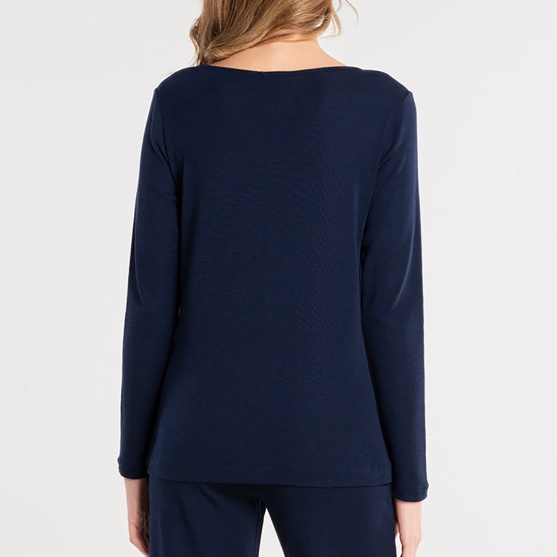 Long sleeve round neck top with keyhole silver metal ring at neckline in dark blue. On model rear view.