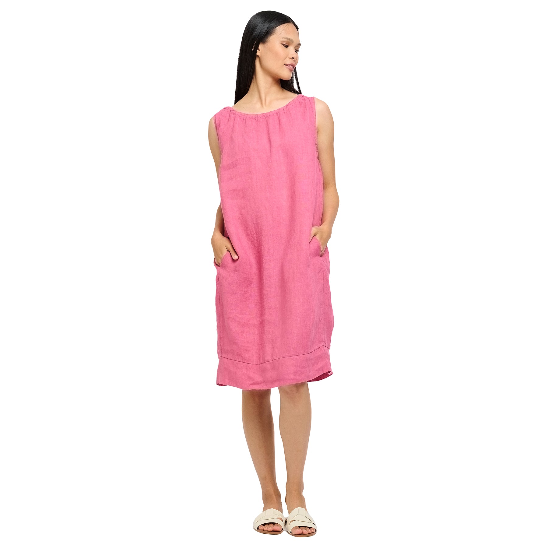 Sleeveless linen dress in pink strawberry with gathered neck and pockets. Front view on model.