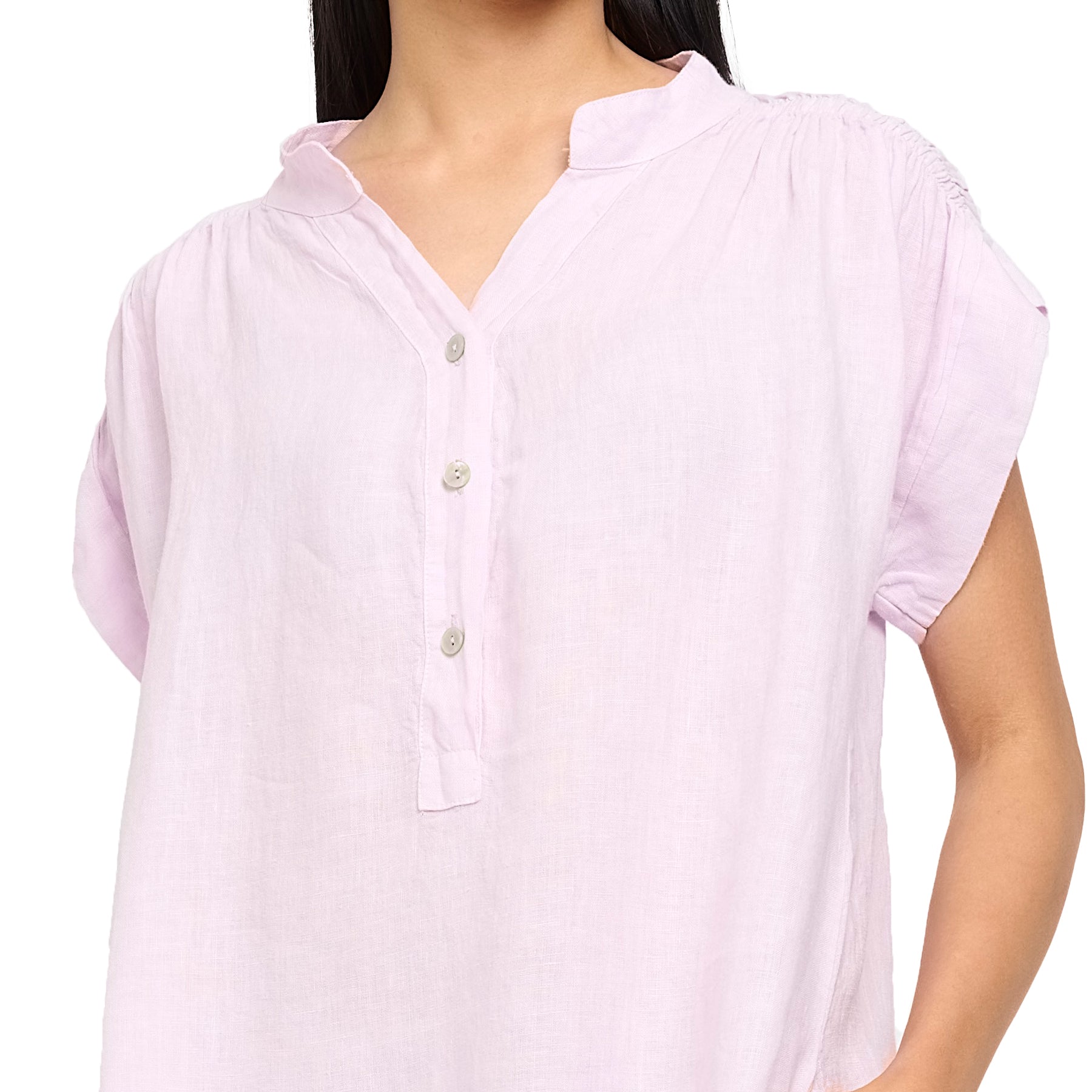 Cap sleeve linen dress in spring lilac with ruched shoulders, henley button up, mock neck, and pockets. Front view close up on model.