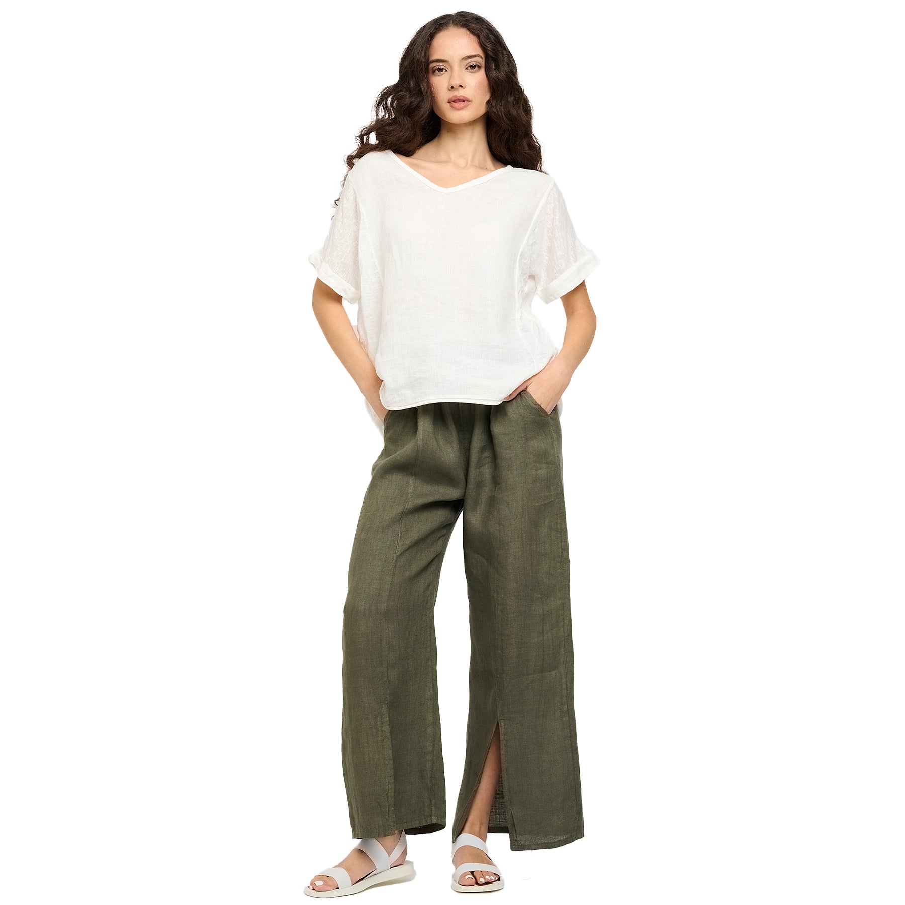 Full view of woman in a white short-sleeve linen top paired with olive green wide-leg pants - relaxed and modern summer outfit.