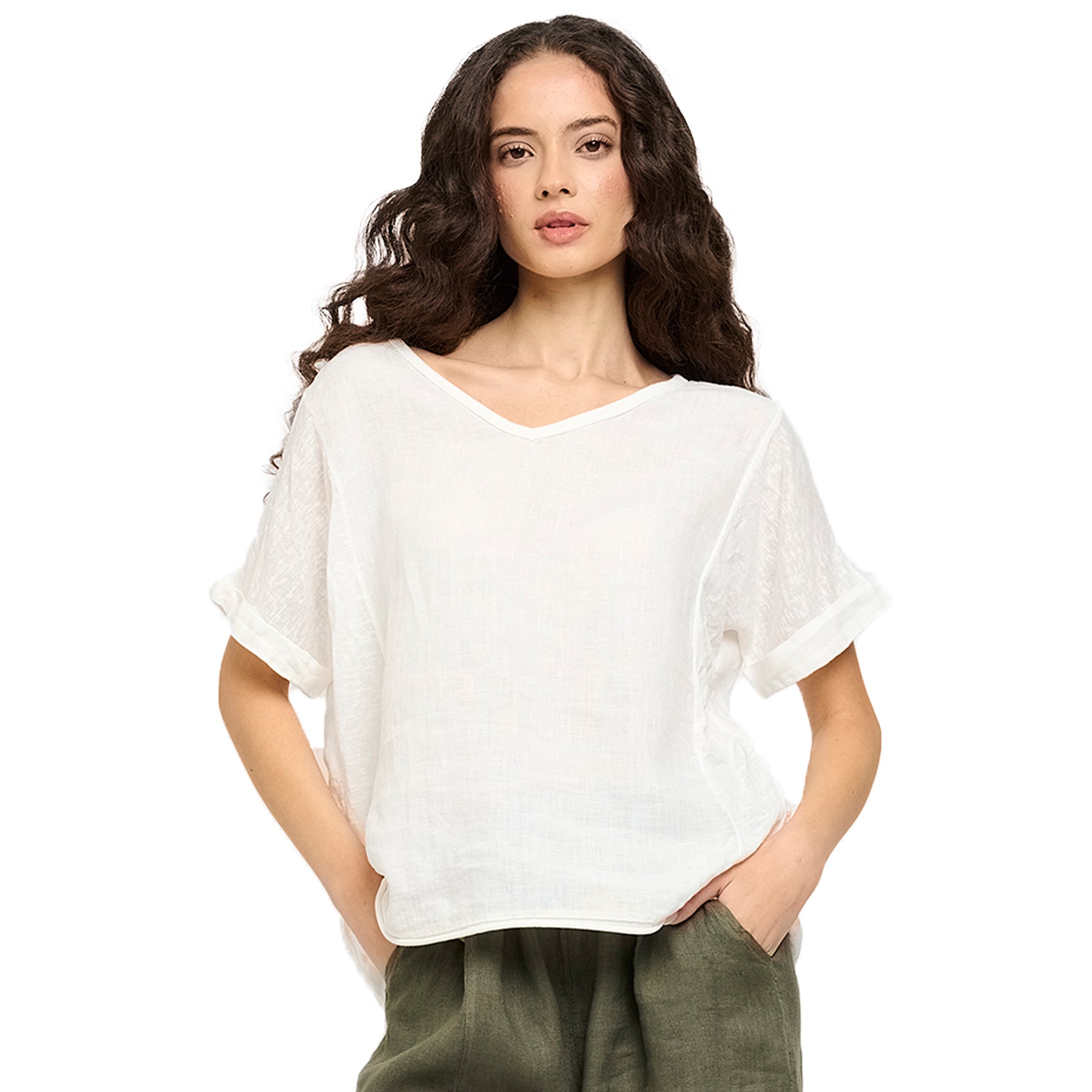 Woman wearing a white short-sleeve V-neck linen top with rolled sleeves and subtle textured panels - lightweight summer style.