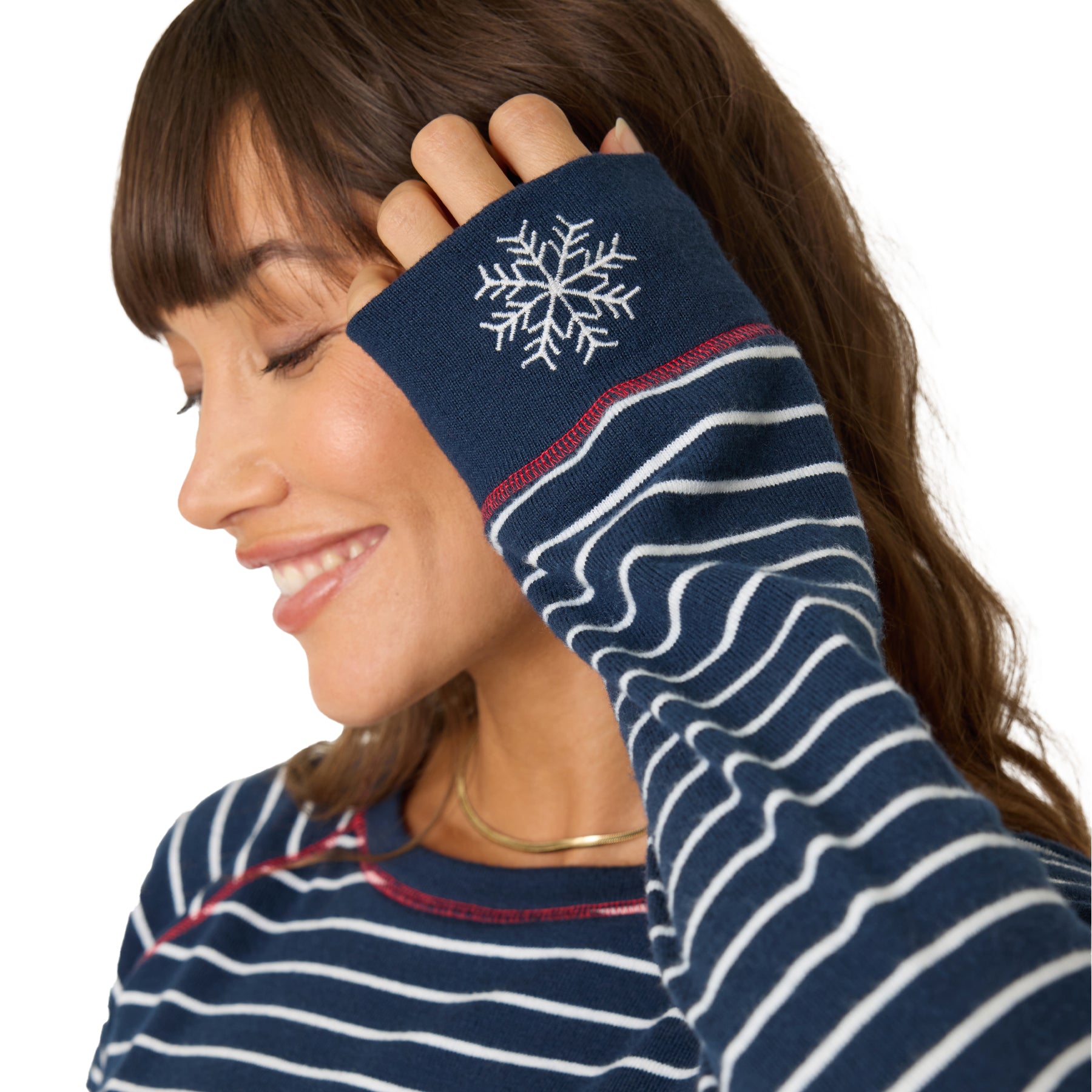 A model wearing a striped printed pajamas, close up look at the sleeve with a snowflake embroidery. 