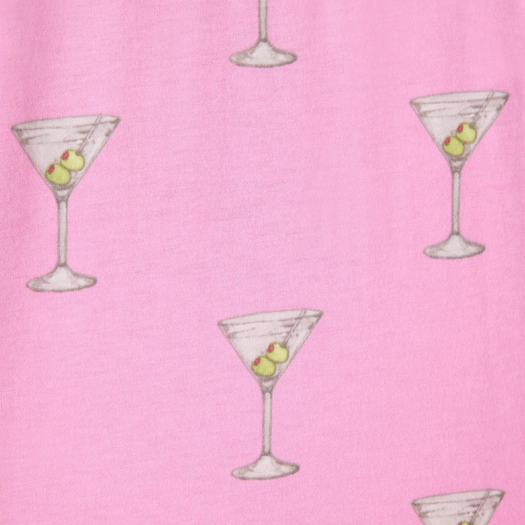 A close-up of pink fabric featuring a martini glass print, each glass filled with olives.