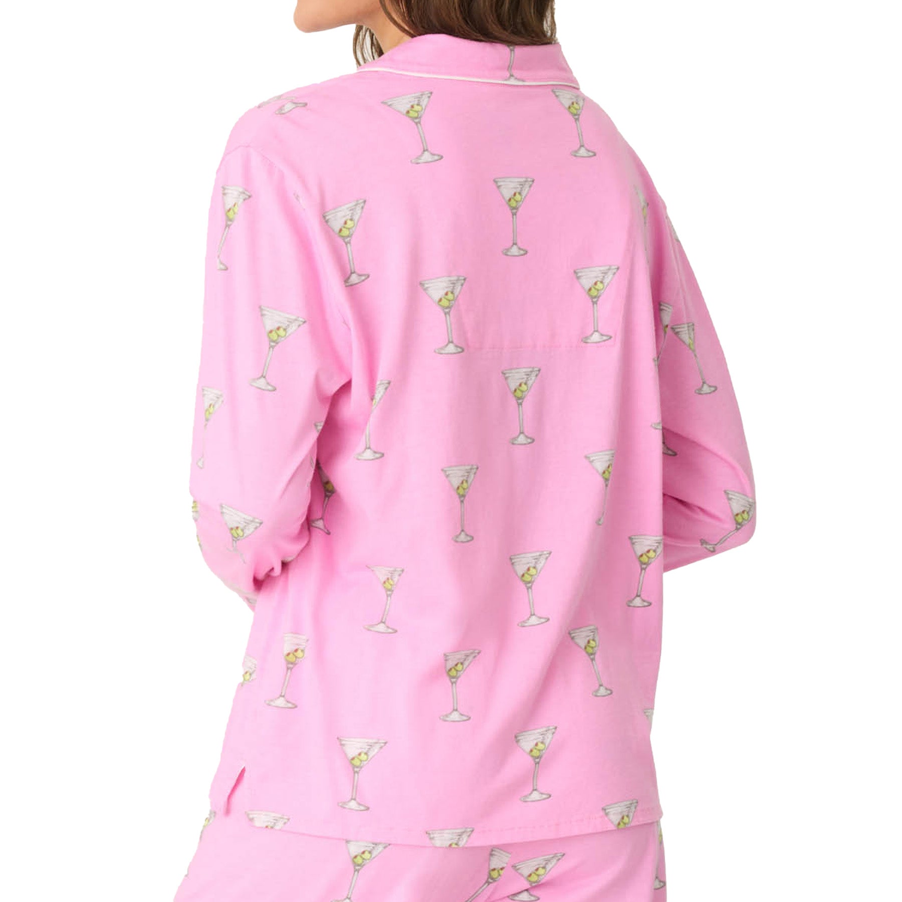 A rear view of a woman wearing a pink martini-print pajama top, showing the full pattern on the back.