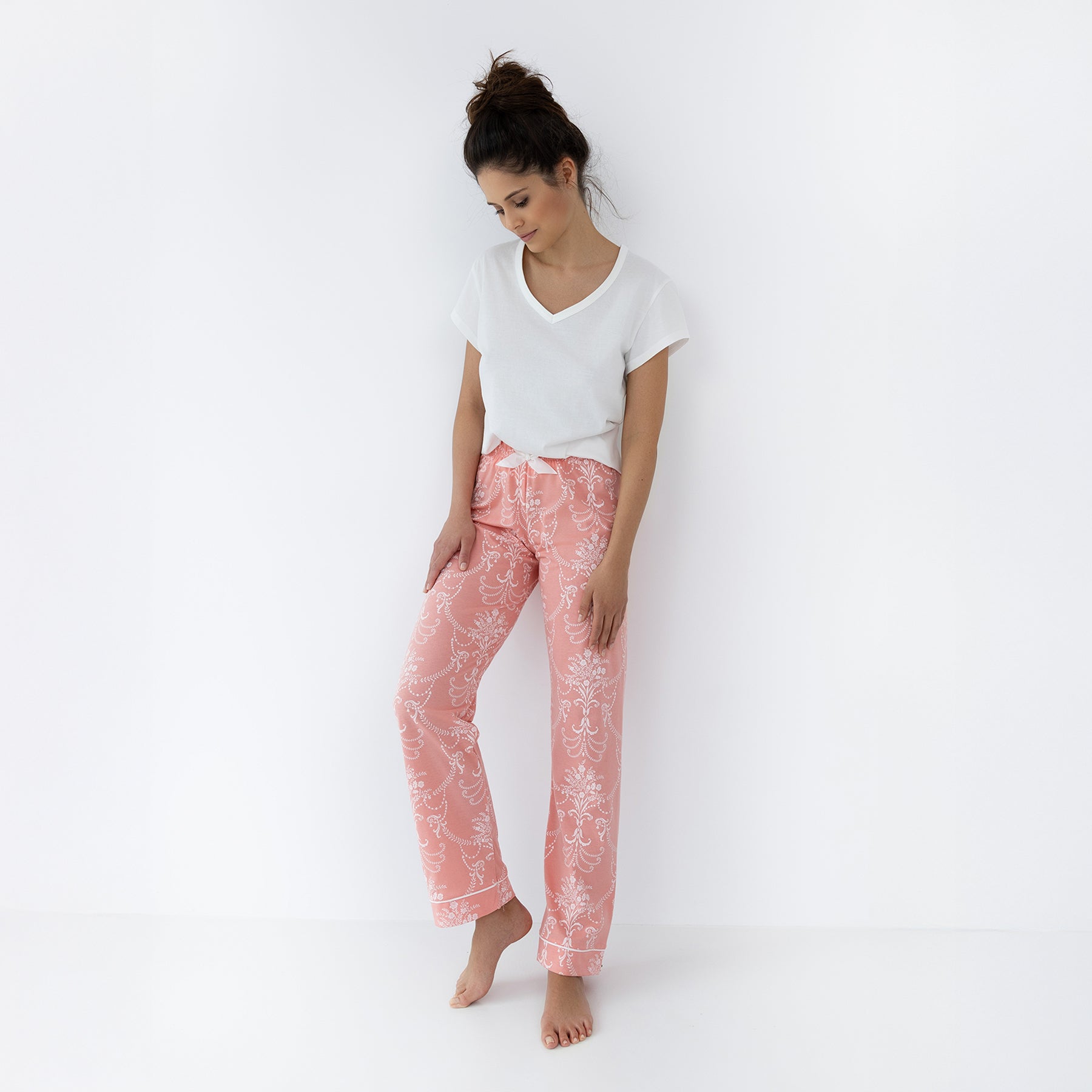 Relaxed coral floral print pants with cuffed hem and white V-neck T-shirt, styled for sleepwear or lounging