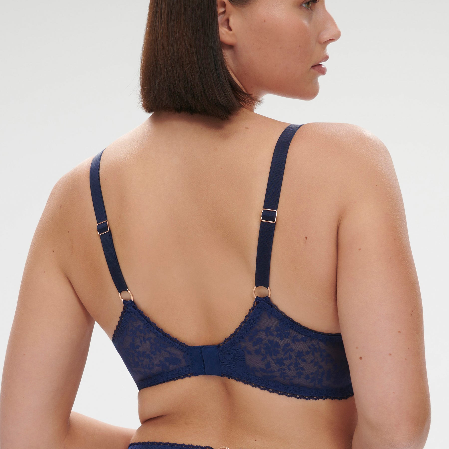 Sheer lace plunge bra with floral embroidery in midnight navy. Rear view on model.