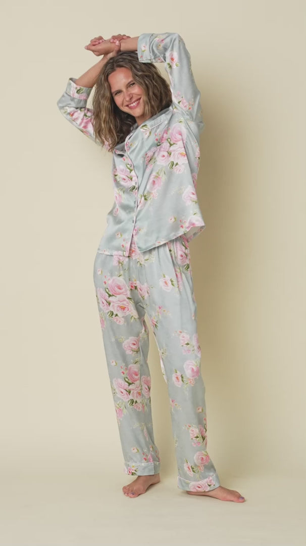 100% silk classic button up pajama set in a multicolour floral print on a light blue background. Model shown turning around to showcase all angles.